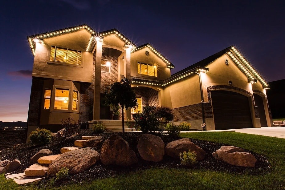A two-storey home at dusk with warm white lighting running the full length of every roofline